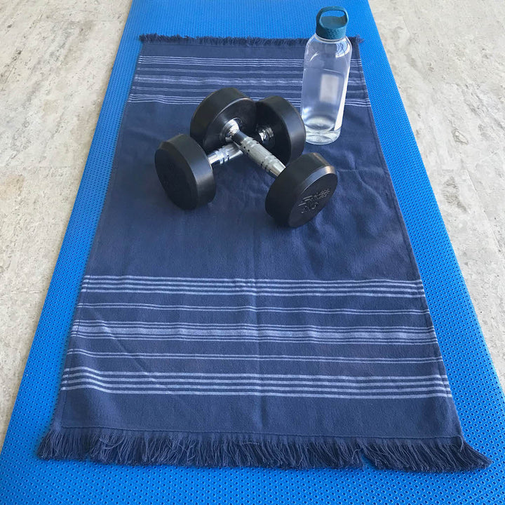 small navy dina terry backed towel open on gym mat